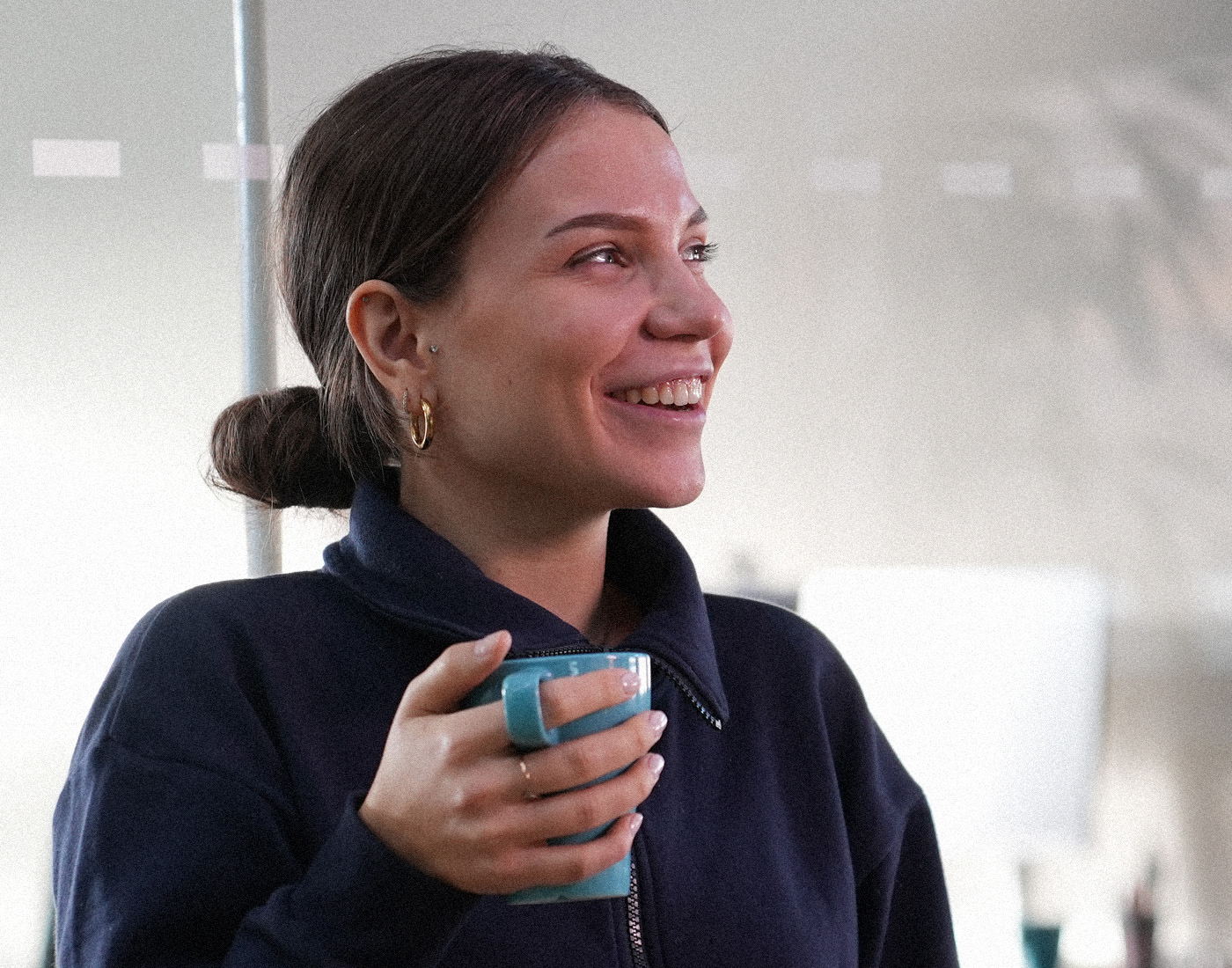 Dieses Bild zeigt einen FederhenSchneider Mitarbeiter in den 20ern mit einem Baseball Cap auf dem Kopf, der eine Kamera vor sein Gesicht hält, als wollte er ein Foto von dem Fotografen machen.