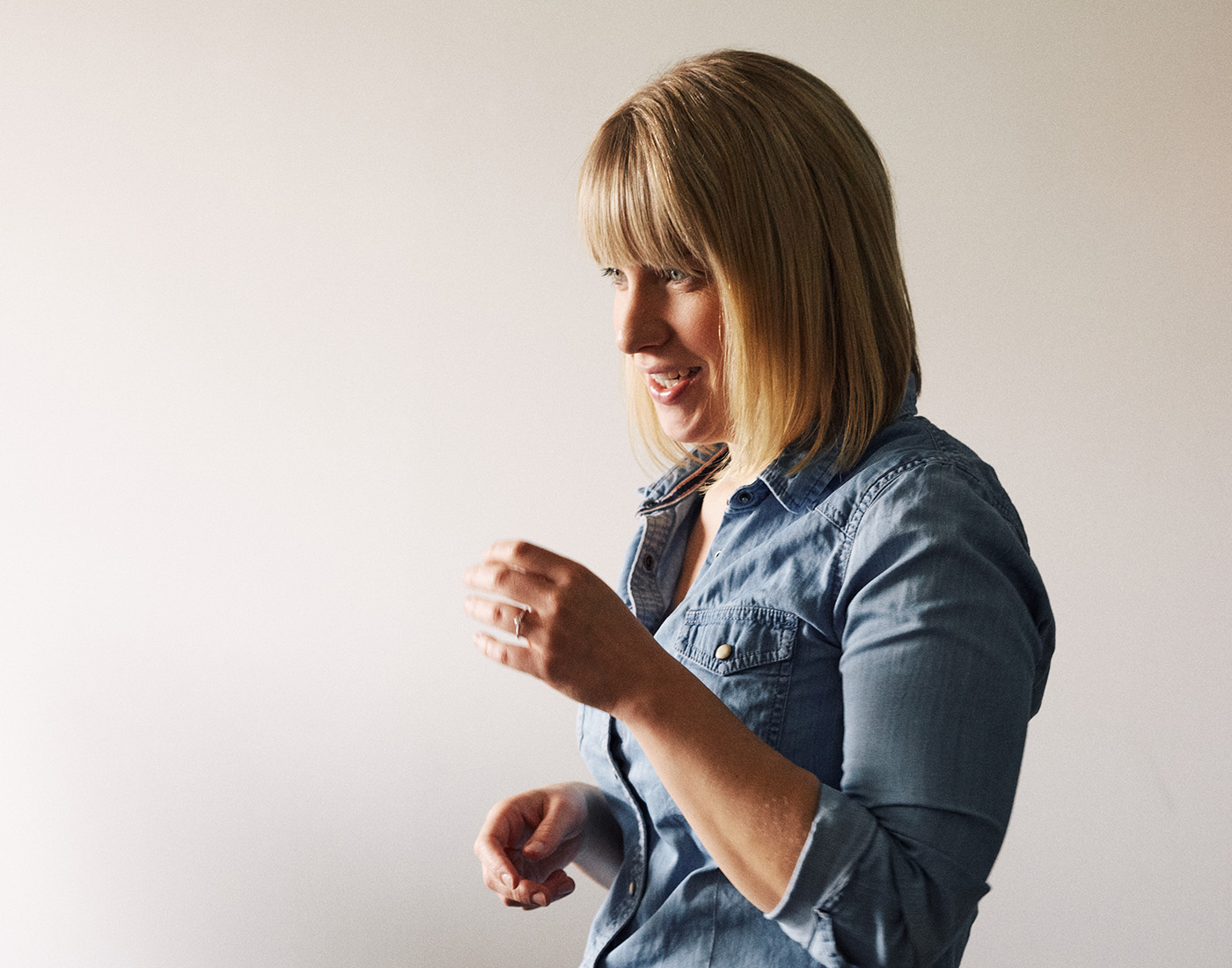 Dieses Bild zeigt eine FederhenSchneider Mitarbeiterin in den 30ern mit halblangen blonden Haaren im Profil. Sie lächelt.