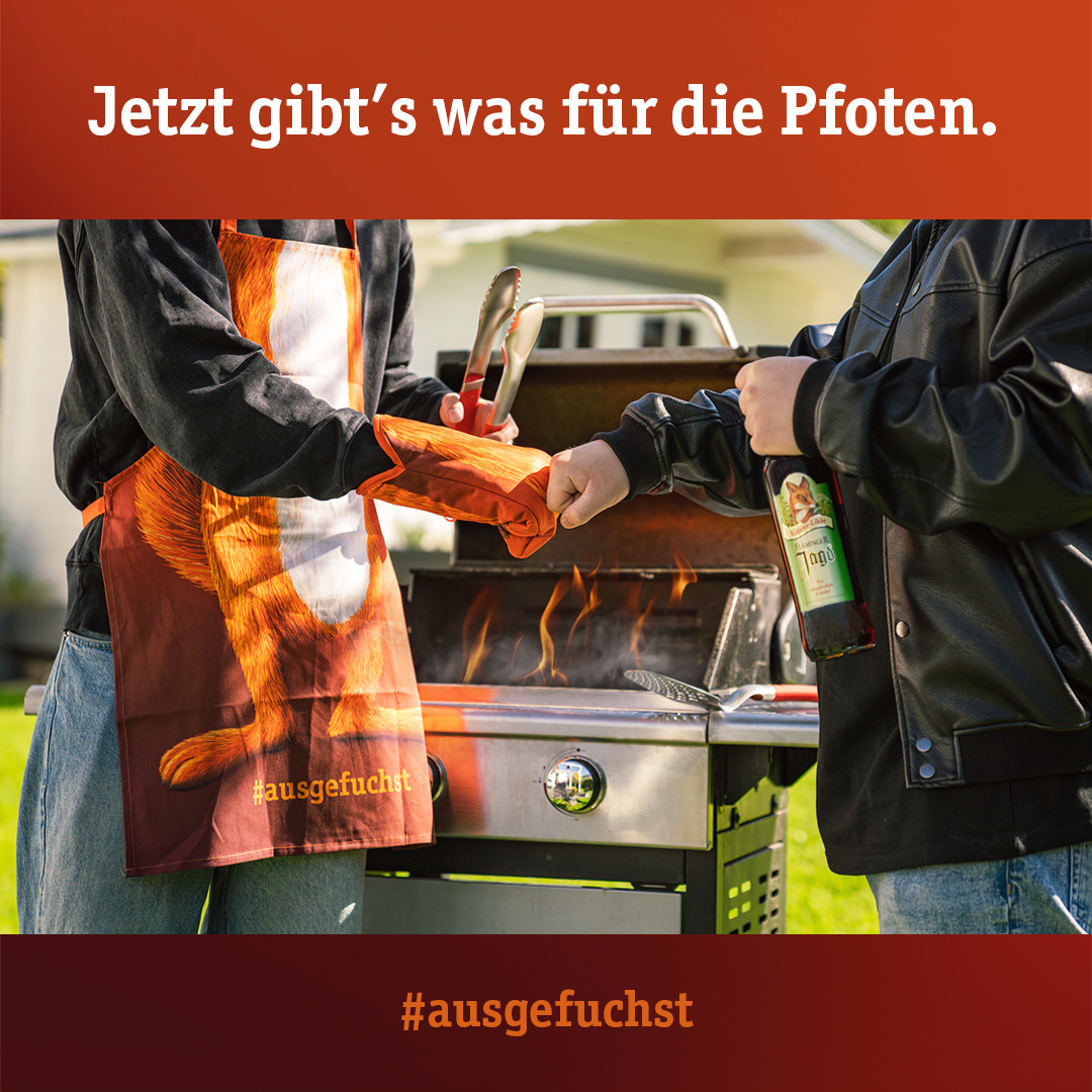 Personen vor einem Grill mit Fläminger Jagd Fanartikeln