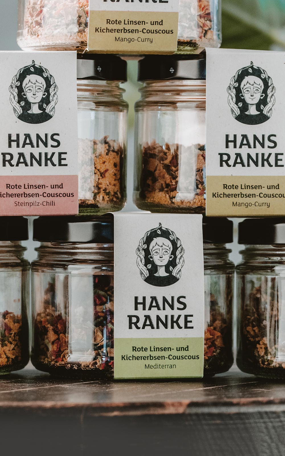 Stapel Gläser mit Superfood aus Linsen, Kichererbsen und Couscous