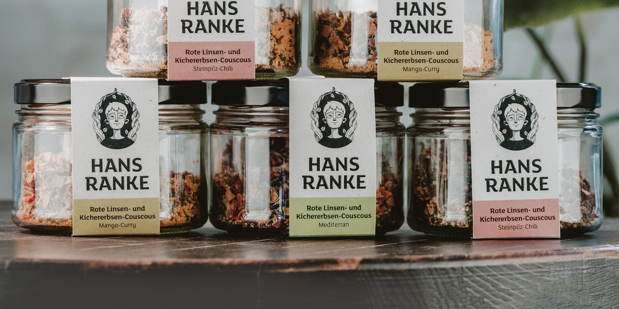 Stapel Gläser mit Superfood aus Linsen, Kichererbsen und Couscous