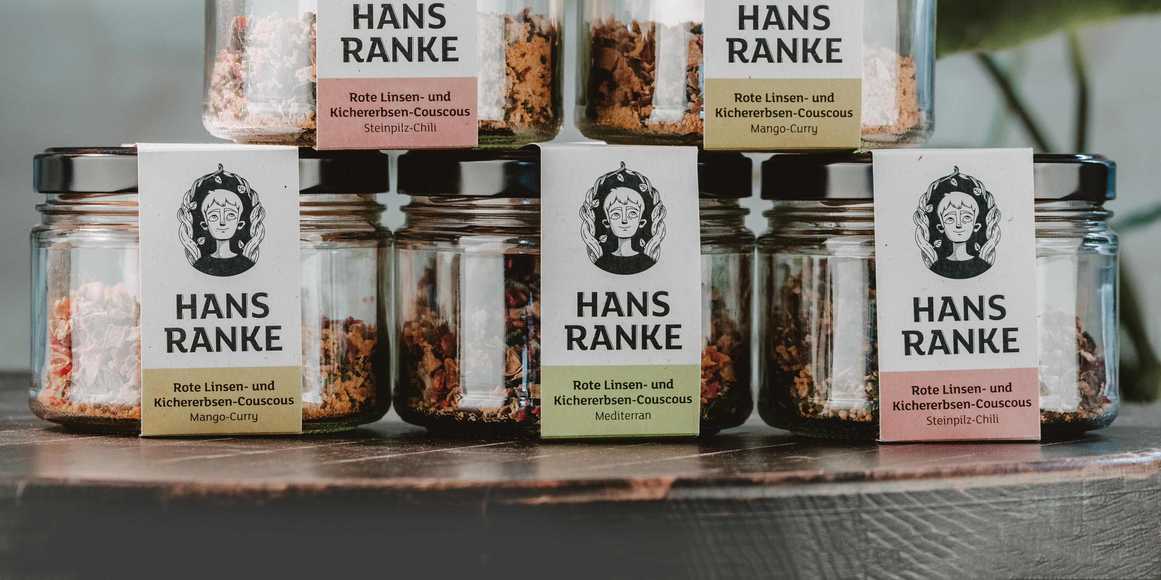 Stapel Gläser mit Superfood aus Linsen, Kichererbsen und Couscous