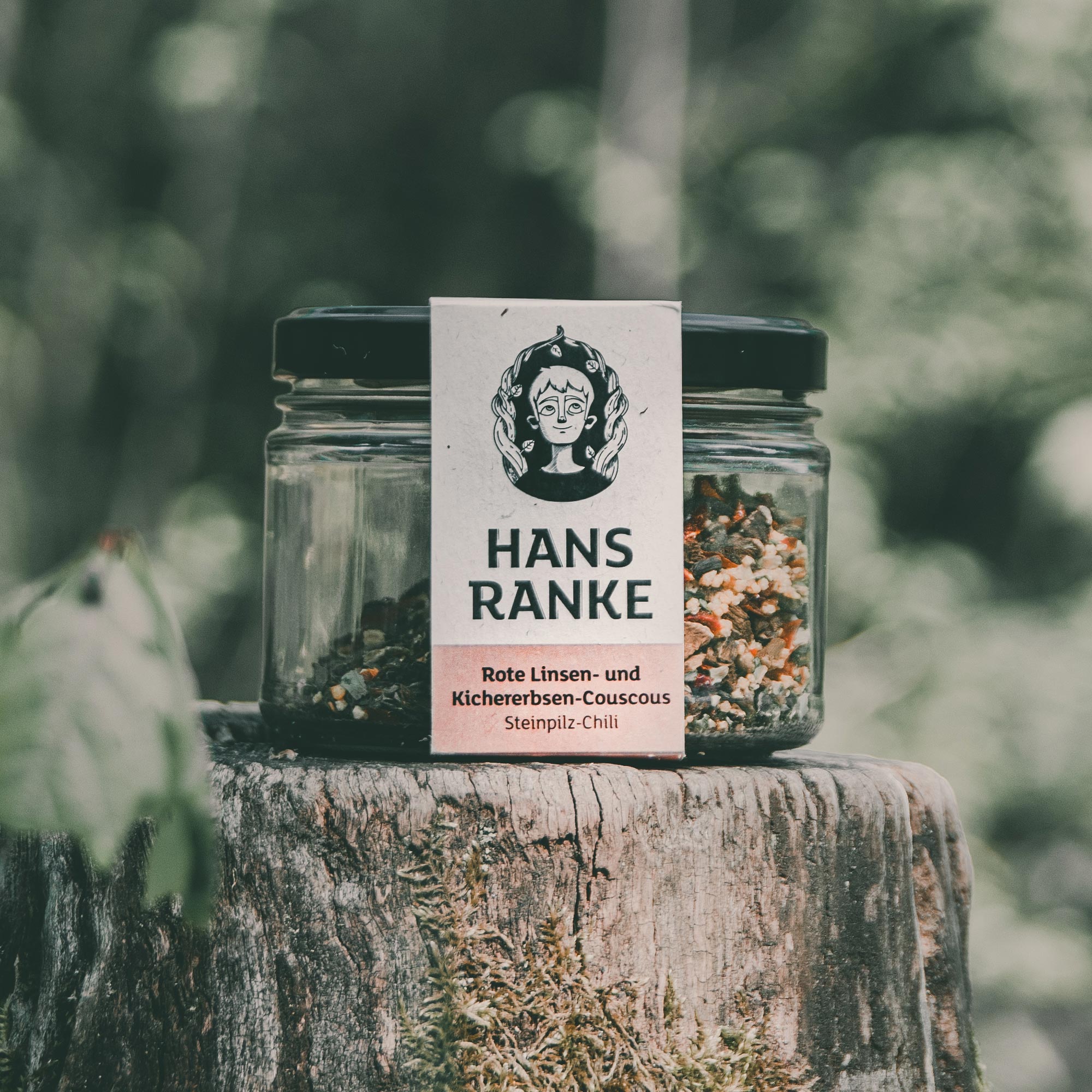 Ein mit Couscous gefülltes Glas auf einem Baumstamm