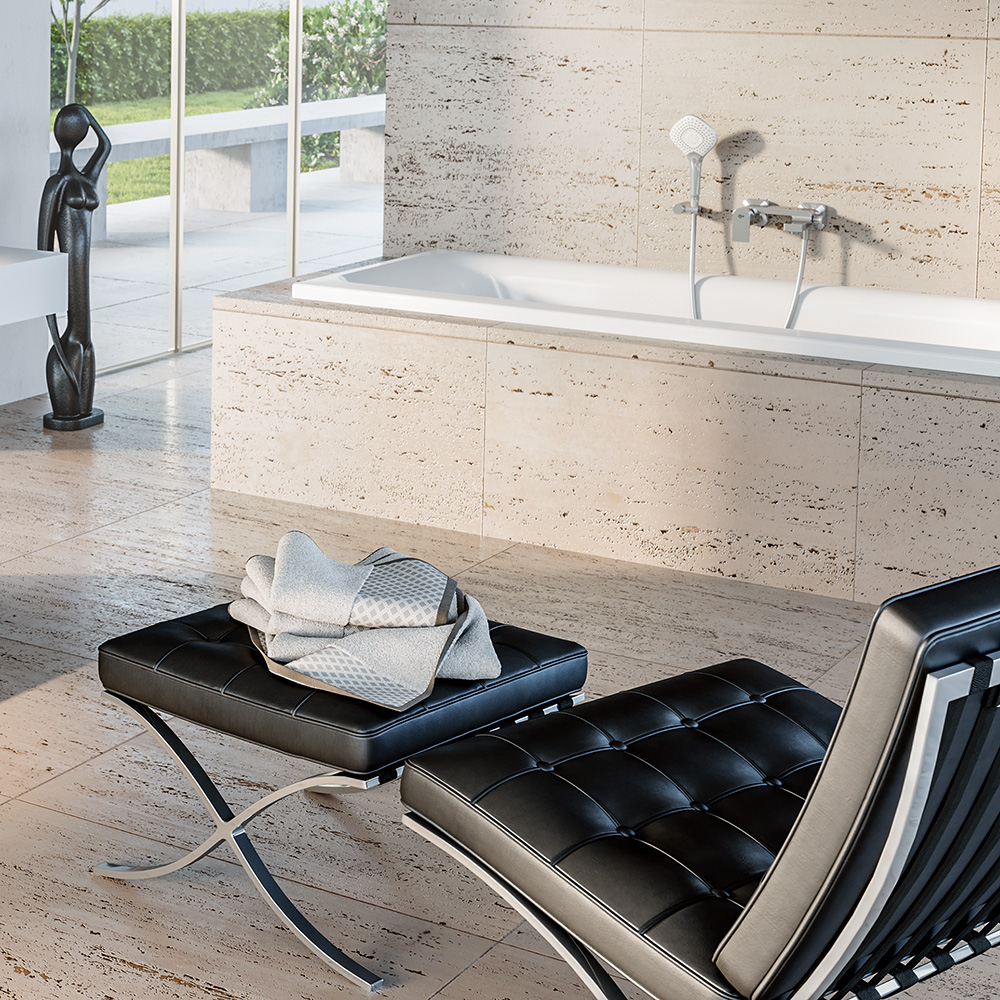 Das Bild zeigt ein modernes, helles Badezimmer mit einer großzügigen Wanne und einem schwarzen Ledersessel auf dem ein Handtuch liegt.