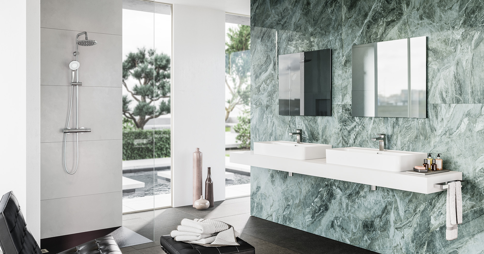 Das Bild zeigt ein modernes, helles Badezimmer als 3D Rendering. Im Hintergrund eine Glasfront, im Vordergrund ein schwebendes Doppelwaschbecken vor dunkelgrünen Marmorfließen, nebst schwarzem Lederhocker, auf dem ein Handtuch liegt.