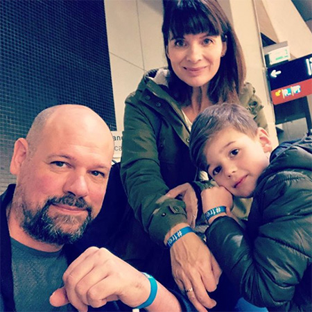 Das Foto zeigt eine Familie. Mutter, Vater und Sohn tragen ein blaues #frei Band.