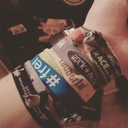 Das Foto zeigt einen ausgestreckten Arm mit diversen Festivalbändern und einem #frei Band.
