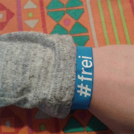 Das Foto zeigt einen ausgestreckten Arm mit einem #frei Band.