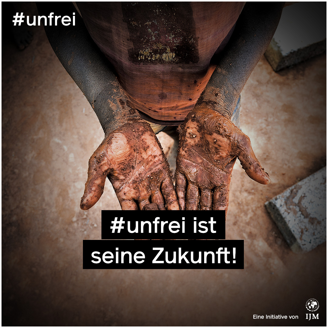 Man sieht zwei dreckige Kinderhände. Darauf die weiße Schrift „#unfrei ist seine Zukunft!“