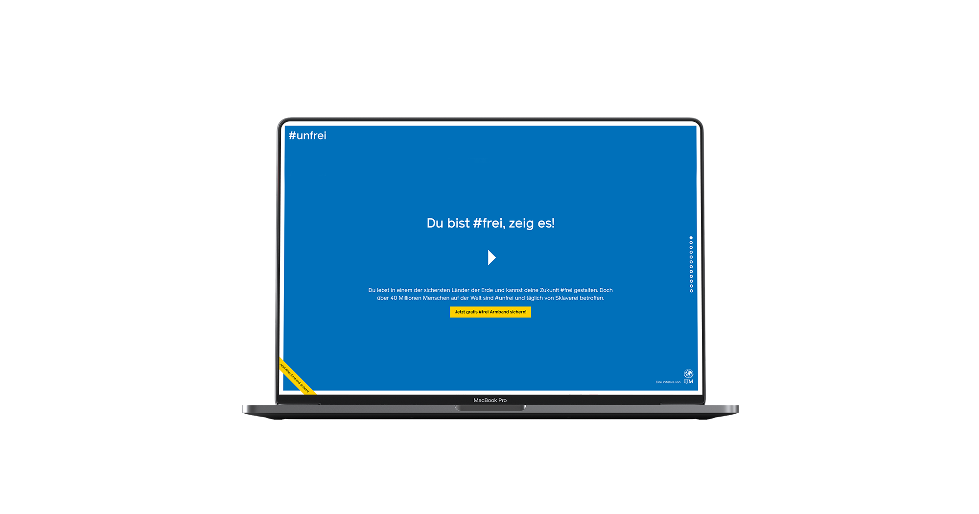 Man sieht einen Laptop, darauf ist die Startseite der unfrei Website zu sehen mit Schrift auf weißem Grund und einem Play-Button.