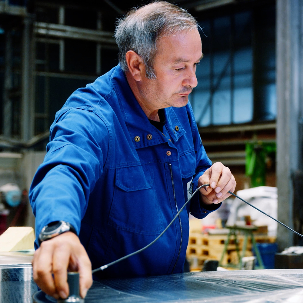 Mitarbeiter bei der Prüfung eines Schmiedestücks – Technik und Expertise im Fokus