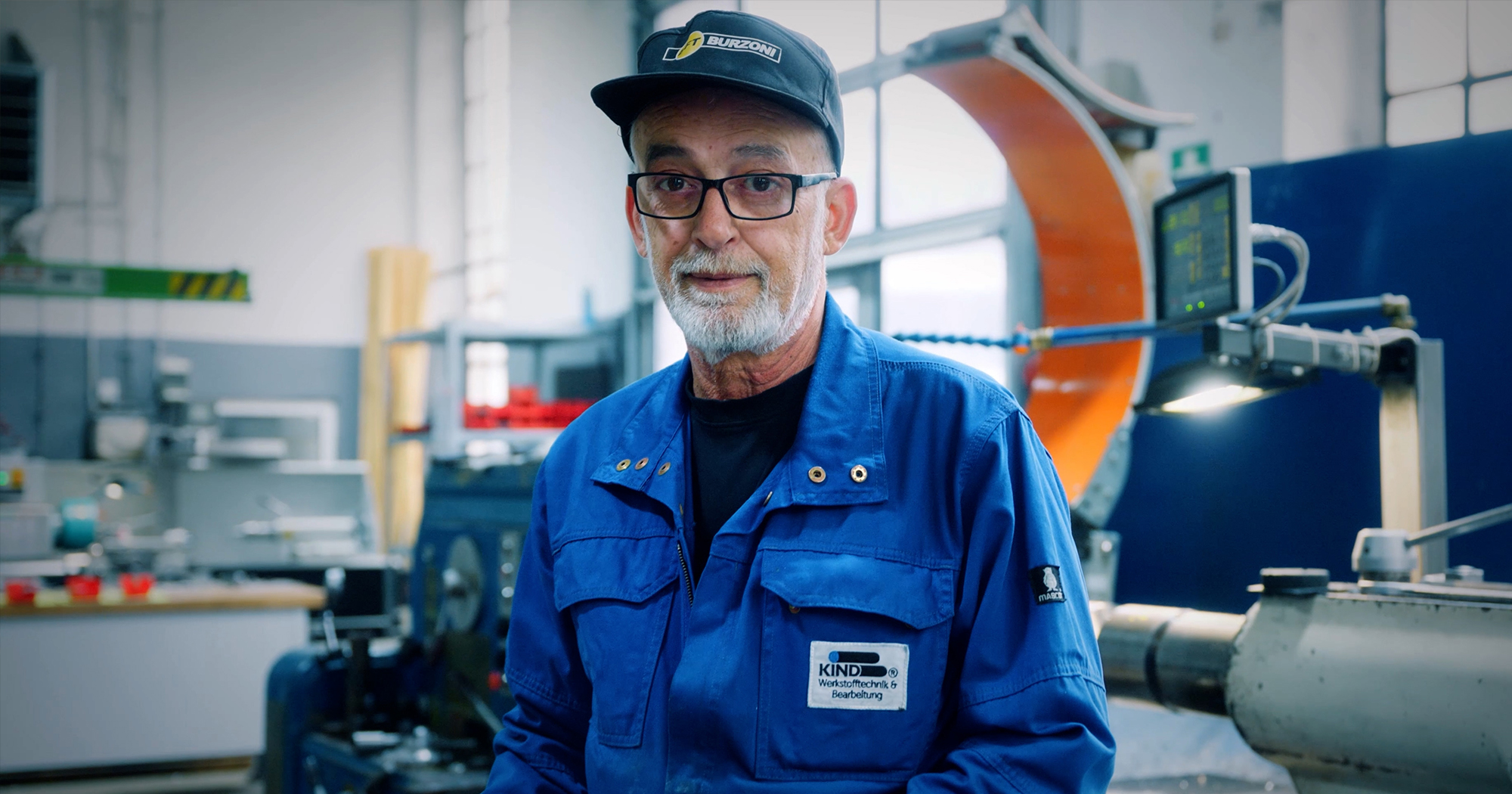 Zwei Geschäftsführer der Rolf Kind GmbH im Gespräch vor industrieller Kulisse