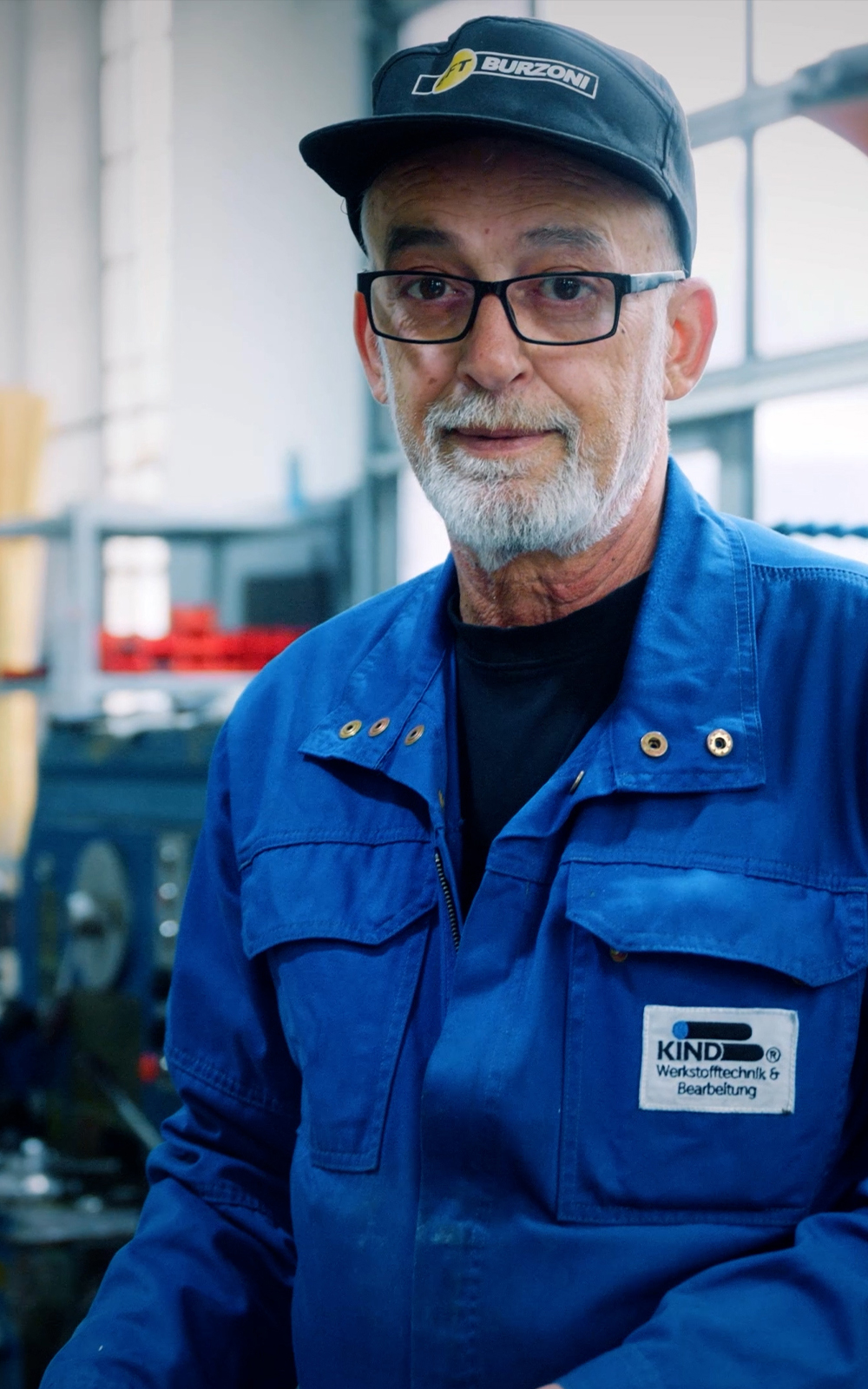 Zwei Geschäftsführer der Rolf Kind GmbH im Gespräch vor industrieller Kulisse