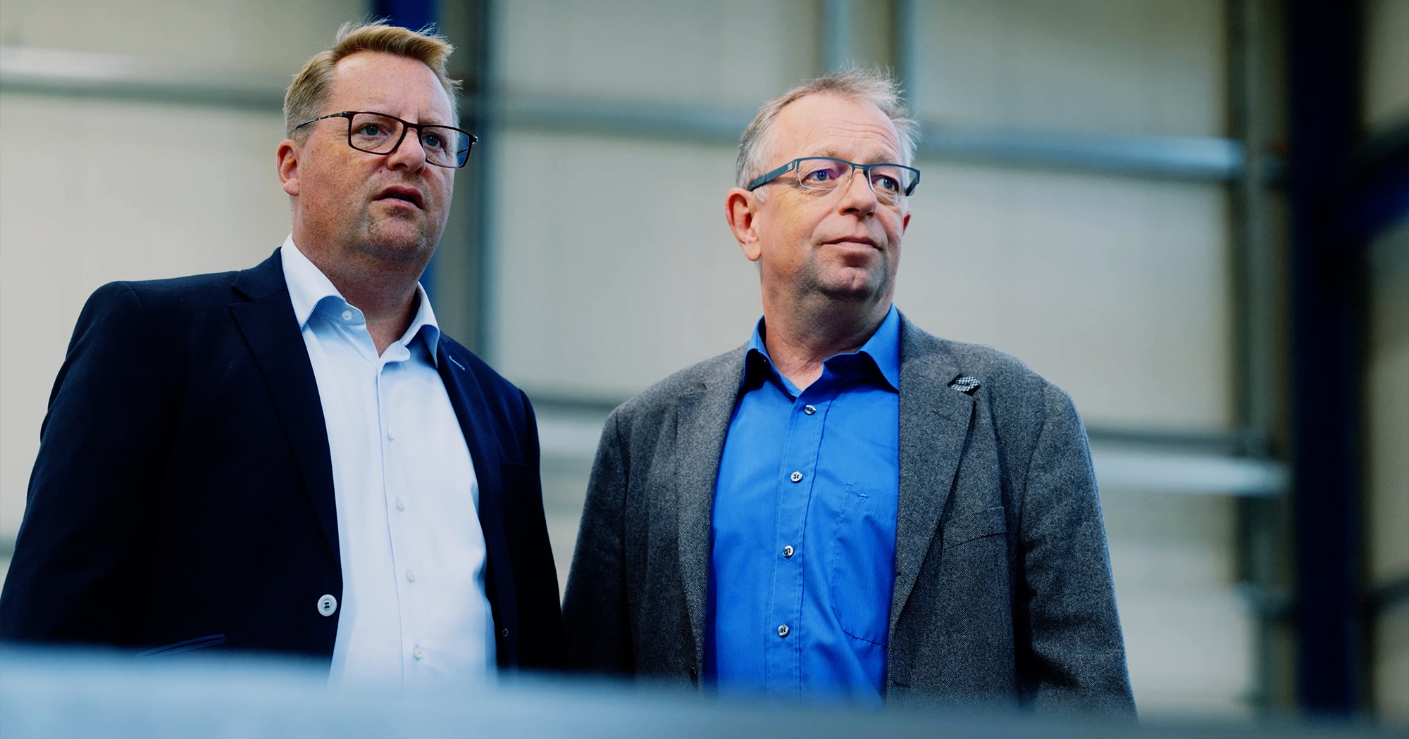 Mitarbeiter der Rolf Kind GmbH in blauer Arbeitskleidung in der Fertigungshalle