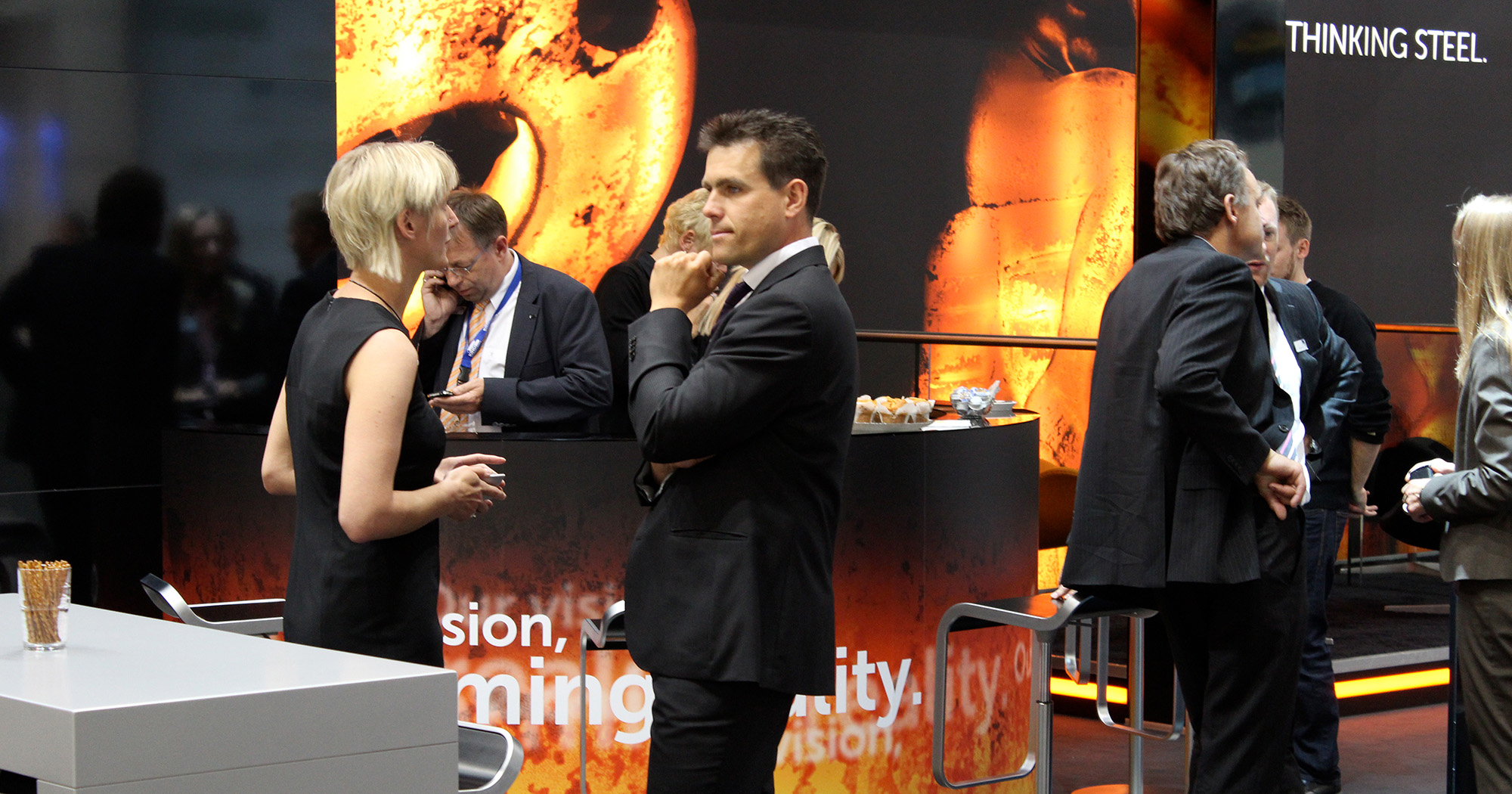 Das Foto zeigt Menschen auf dem Messestand von RKind, die sich unterhalten.