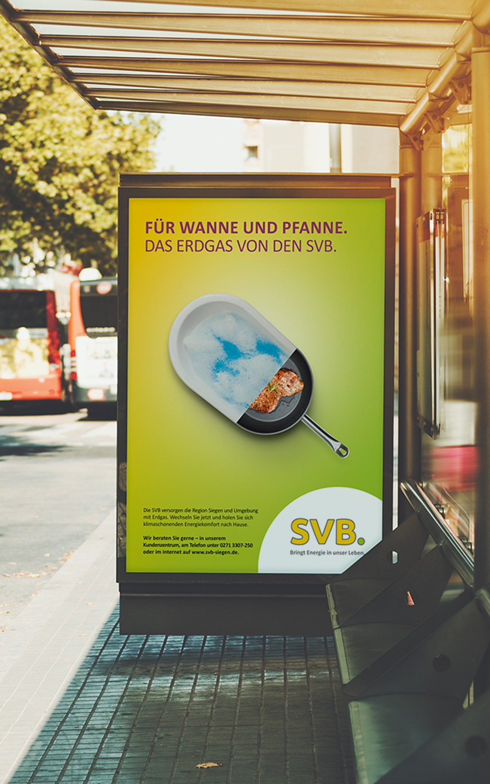 Das Foto zeigt ein Citylight an einer Bushaltestelle. Man sieht ein Poster, auf dem ein Motiv, das halb Badewanne und halb Bratpfanne zeigt, abgebildet ist. Darüber die Headline „Für Wanne und Pfanne. Das Erdgas von den SVB.“ auf gelb/grünem Grund.
