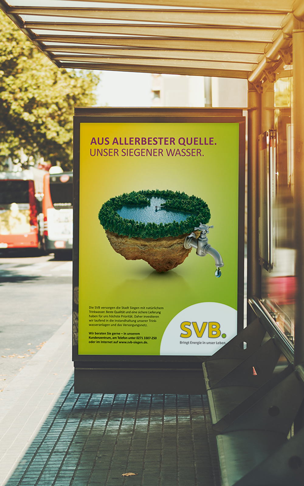 Das Foto zeigt ein Citylight an einer Bushaltestelle. Man sieht ein Poster, auf dem ein Bild eines Sees aus dem ein Wasserhahn kommt, abgebildet ist. Darüber die Headline „Aus allerbester Quelle. Unser Siegener Wasser.“ auf gelb/grünem Grund.